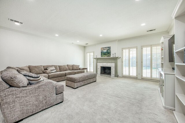 carpeted living room with a healthy amount of sunlight, ornamental molding, and a textured ceiling