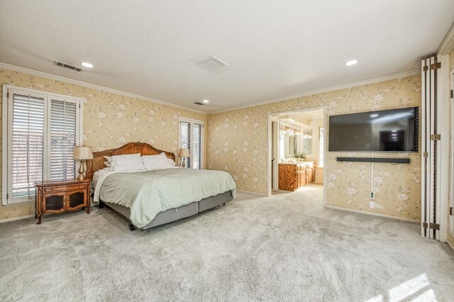 bedroom featuring light colored carpet, ensuite bathroom, and crown molding