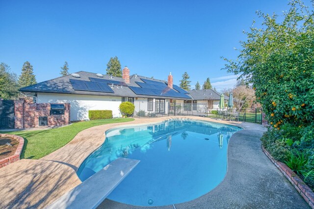 view of pool with a patio area and a diving board