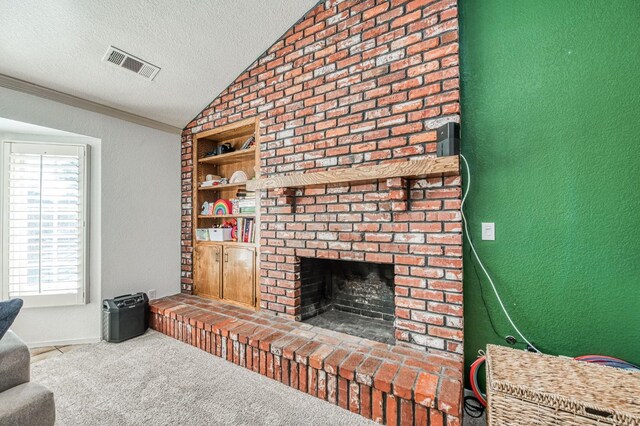 living room with vaulted ceiling, a brick fireplace, carpet flooring, a textured ceiling, and built in shelves