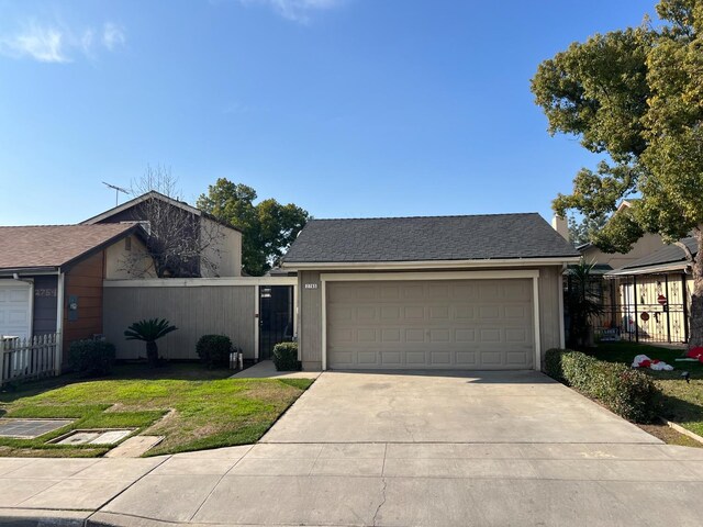 ranch-style home featuring a garage and a front lawn