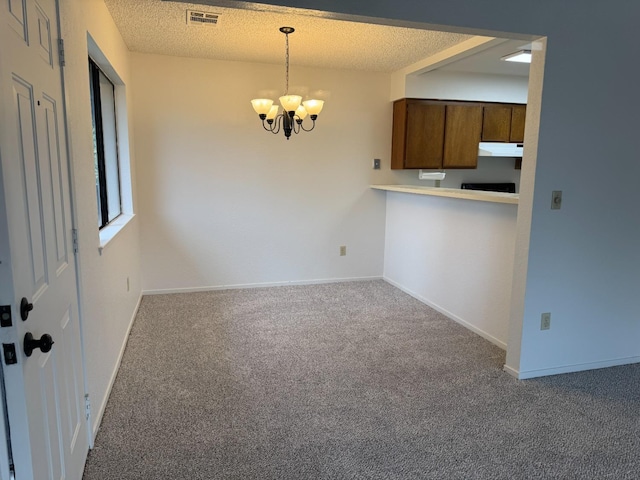 kitchen featuring carpet flooring, a textured ceiling, pendant lighting, and a chandelier