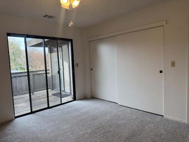 empty room with a textured ceiling and carpet floors