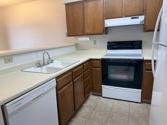 kitchen featuring white appliances, light tile patterned flooring, and sink