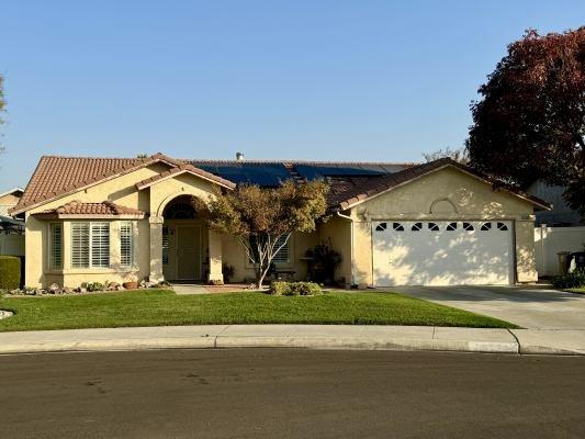 view of front of home featuring solar panels, a garage, and a front lawn