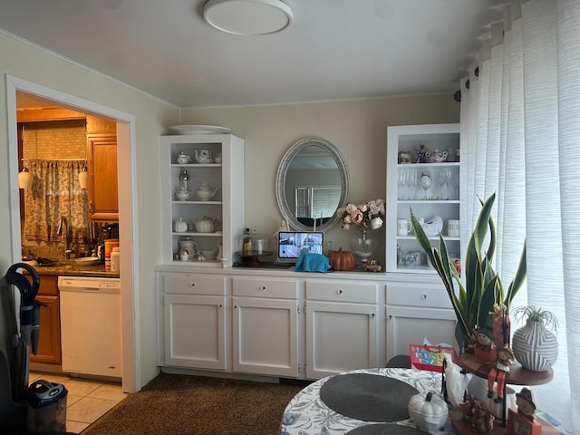 bar featuring dishwasher, white cabinetry, sink, and light tile patterned floors