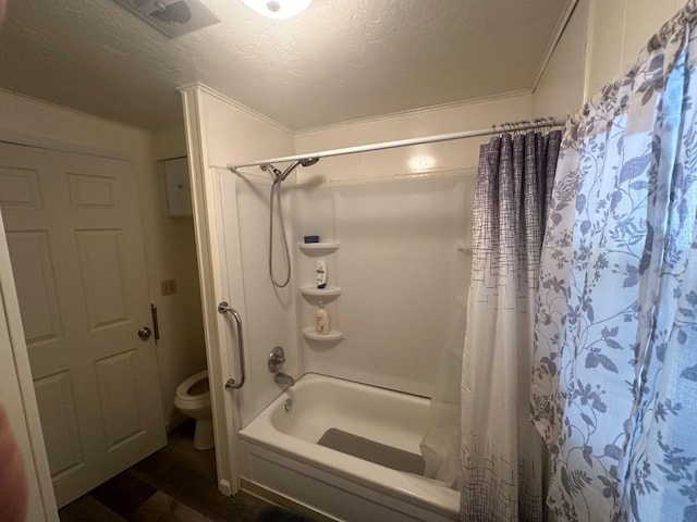 bathroom featuring shower / bath combo, toilet, ornamental molding, and a textured ceiling