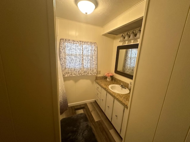 bathroom featuring vanity, wood-type flooring, and a textured ceiling