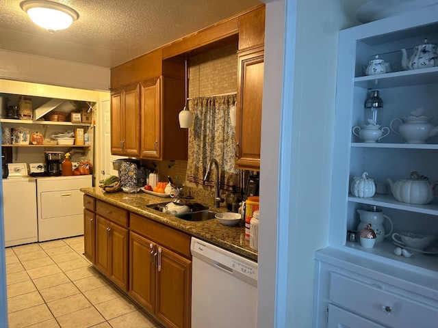 kitchen featuring sink, light tile patterned floors, built in features, dishwasher, and washing machine and dryer