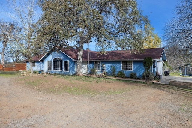 ranch-style house with a trampoline and a front yard