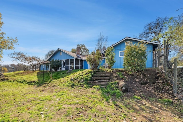 back of house with a yard and a sunroom