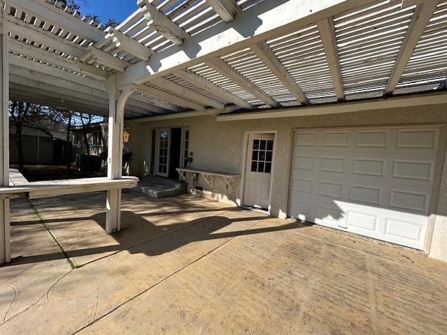 view of patio / terrace featuring a garage and a pergola