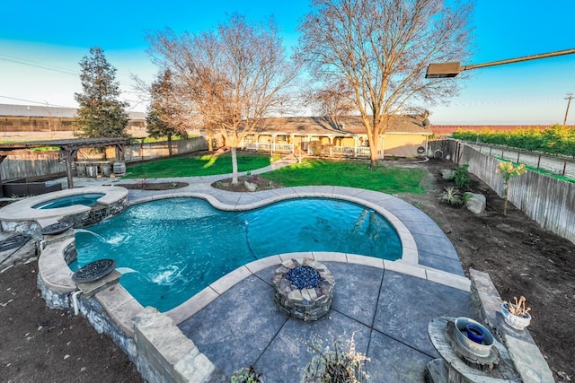 view of pool featuring pool water feature, a yard, and an in ground hot tub