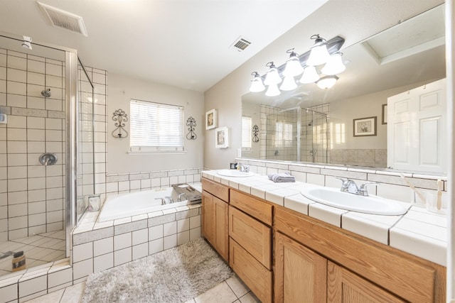 bathroom featuring tile patterned flooring, vanity, and separate shower and tub