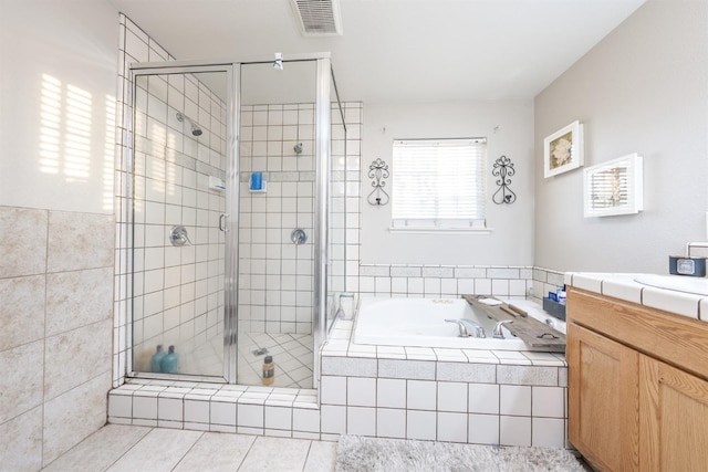 bathroom featuring tile patterned floors, vanity, and shower with separate bathtub