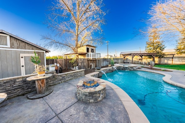 view of pool featuring an in ground hot tub, pool water feature, an outdoor fire pit, and a patio area