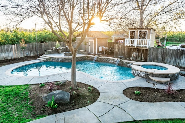 view of swimming pool with an outdoor structure, pool water feature, and an in ground hot tub