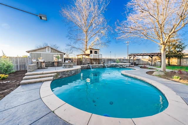 view of swimming pool featuring pool water feature and an outdoor structure