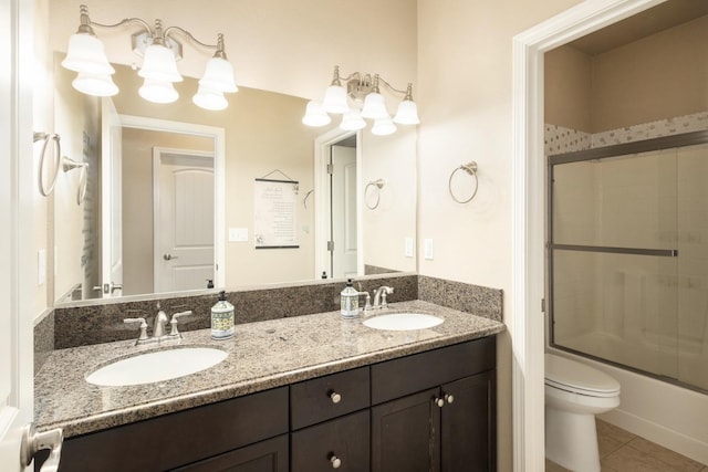 full bathroom featuring tile patterned floors, vanity, enclosed tub / shower combo, and toilet