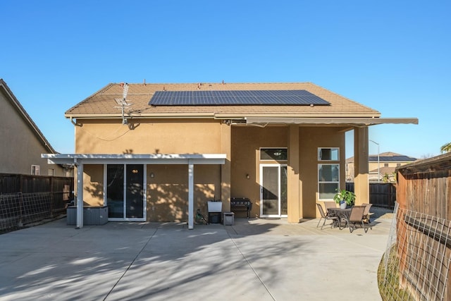 back of property featuring a patio area and solar panels