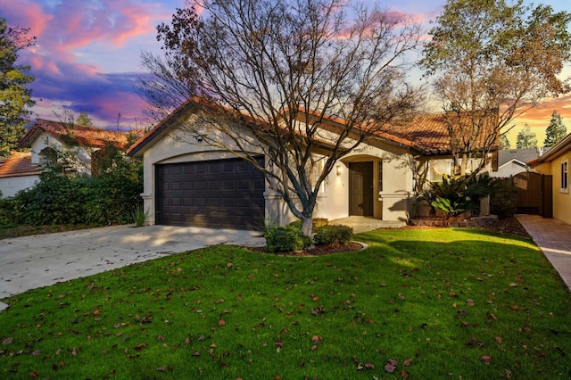 view of front of house featuring a garage and a lawn