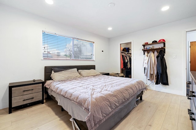 bedroom with a spacious closet, a closet, and light wood-type flooring