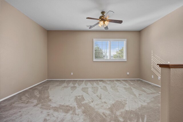 carpeted spare room with ceiling fan