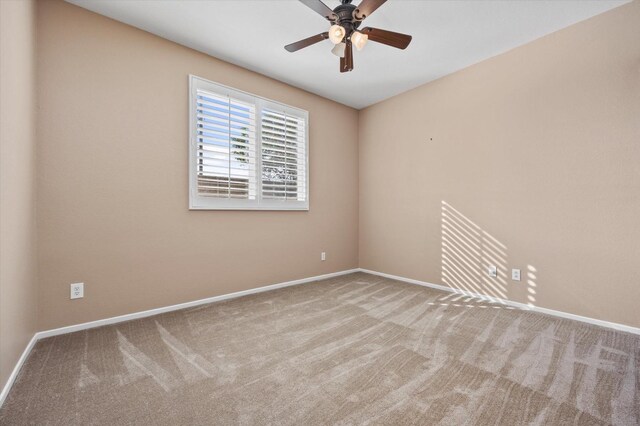 carpeted spare room with ceiling fan