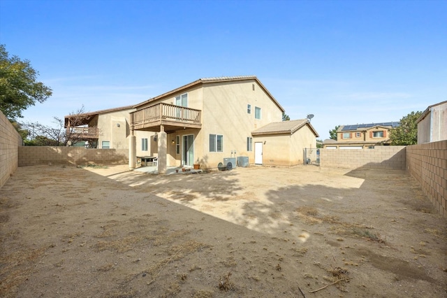 back of house featuring a patio area, a balcony, and central AC unit