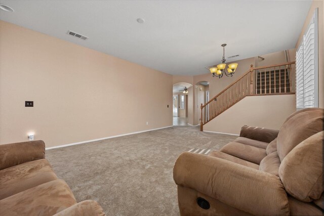 living room with light carpet and a notable chandelier