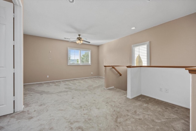 carpeted spare room featuring ceiling fan