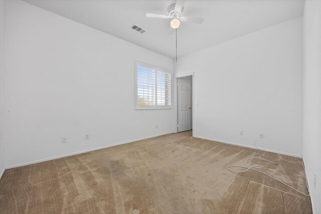 carpeted spare room with ceiling fan