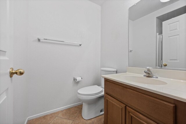 bathroom with tile patterned flooring, vanity, and toilet