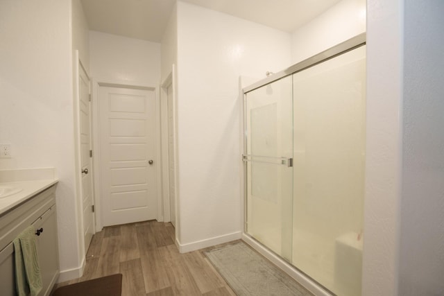 bathroom with vanity, an enclosed shower, and wood-type flooring