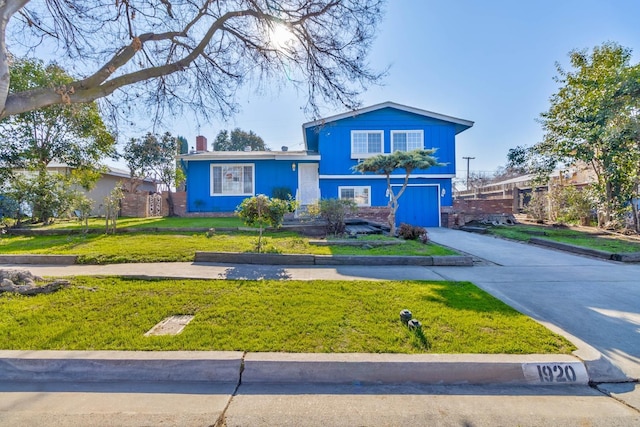 tri-level home featuring a garage and a front lawn