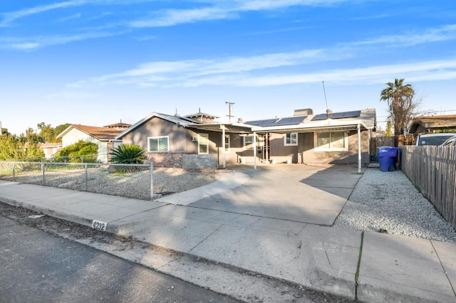 ranch-style home featuring solar panels