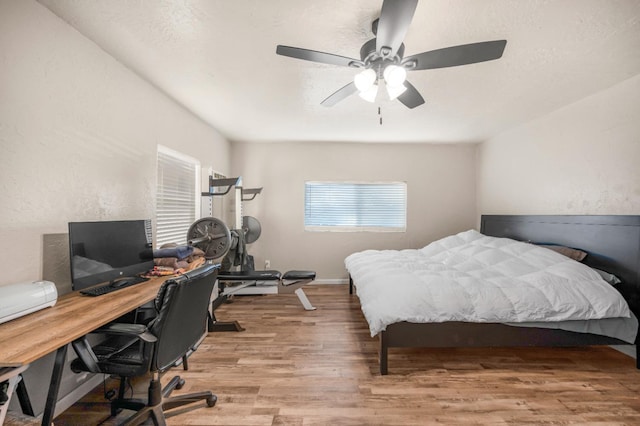 bedroom with light hardwood / wood-style floors and ceiling fan