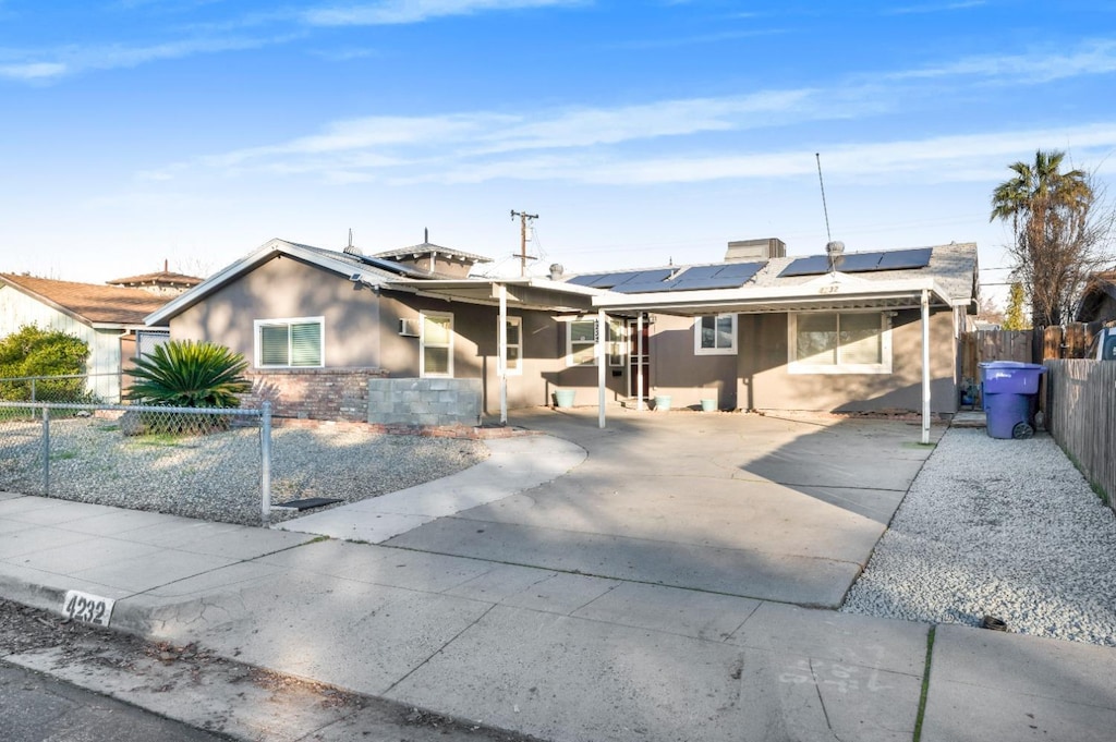 view of front of property with a patio area and solar panels