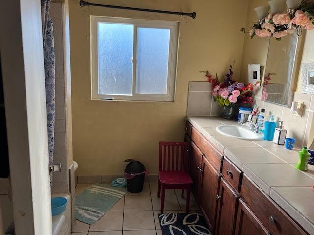 bathroom with tile patterned floors, vanity, and shower / tub combo