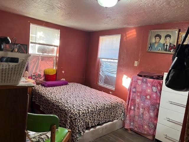 bedroom with a textured ceiling and hardwood / wood-style flooring