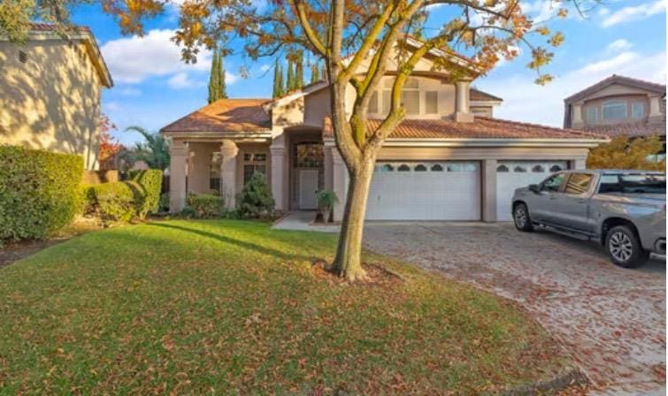 view of front of property with a front yard and a garage