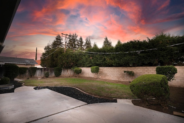 yard at dusk with a patio area