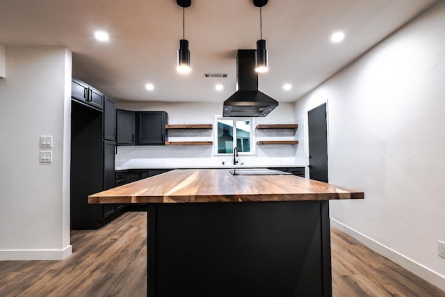 kitchen featuring island range hood, wooden counters, pendant lighting, and a center island