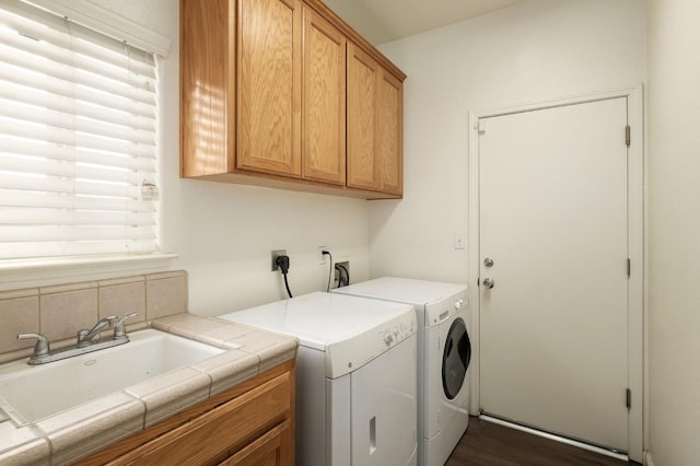 laundry room with dark hardwood / wood-style floors, cabinets, separate washer and dryer, and sink