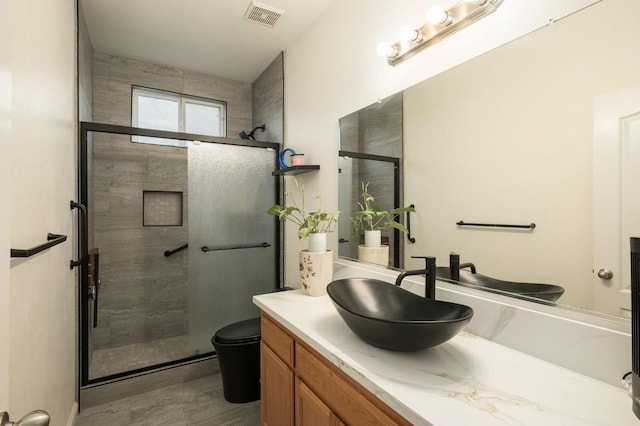 bathroom with toilet, vanity, and walk in shower