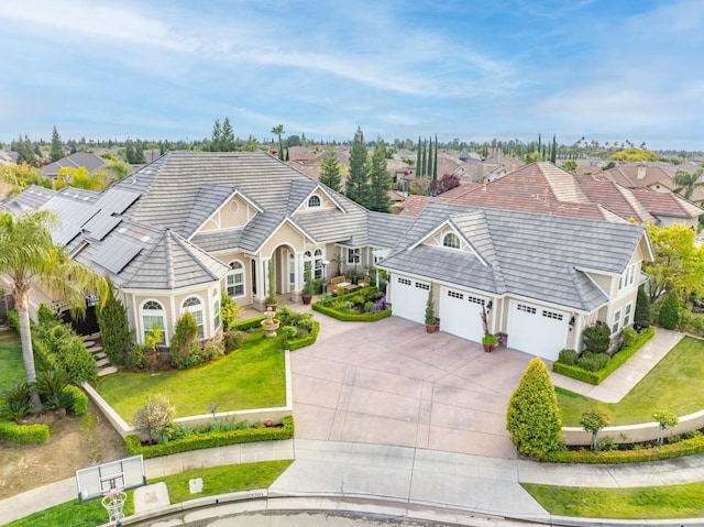 view of front of house with solar panels, a garage, and a front yard