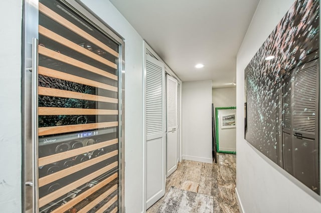 corridor featuring recessed lighting, baseboards, and wine cooler