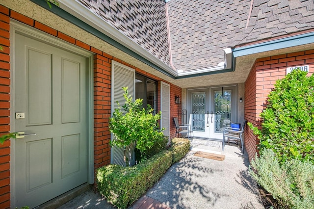 view of exterior entry with brick siding and french doors