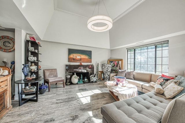 living area with a high ceiling, ornamental molding, and wood finished floors