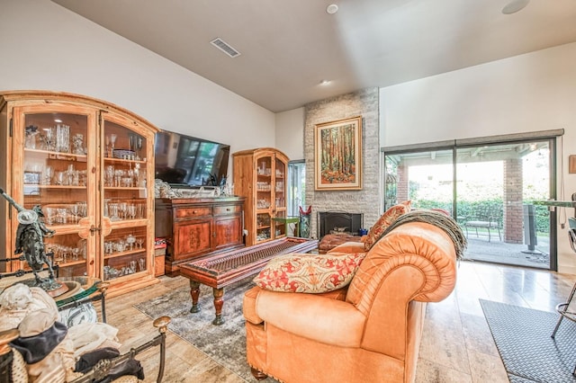 living room featuring visible vents and a stone fireplace